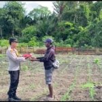 Kapolsek Pantai Timur Polda Papua Bagikan Bendera Merah Putih Kepada Masyarakat