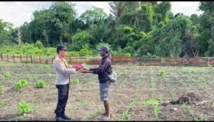 Kapolsek Pantai Timur Polda Papua Bagikan Bendera Merah Putih Kepada Masyarakat